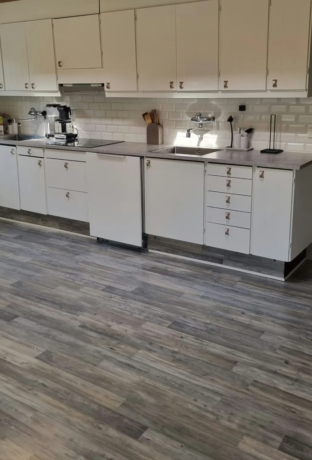 Long white kitchen with two sinks, induction hob and coffee maker