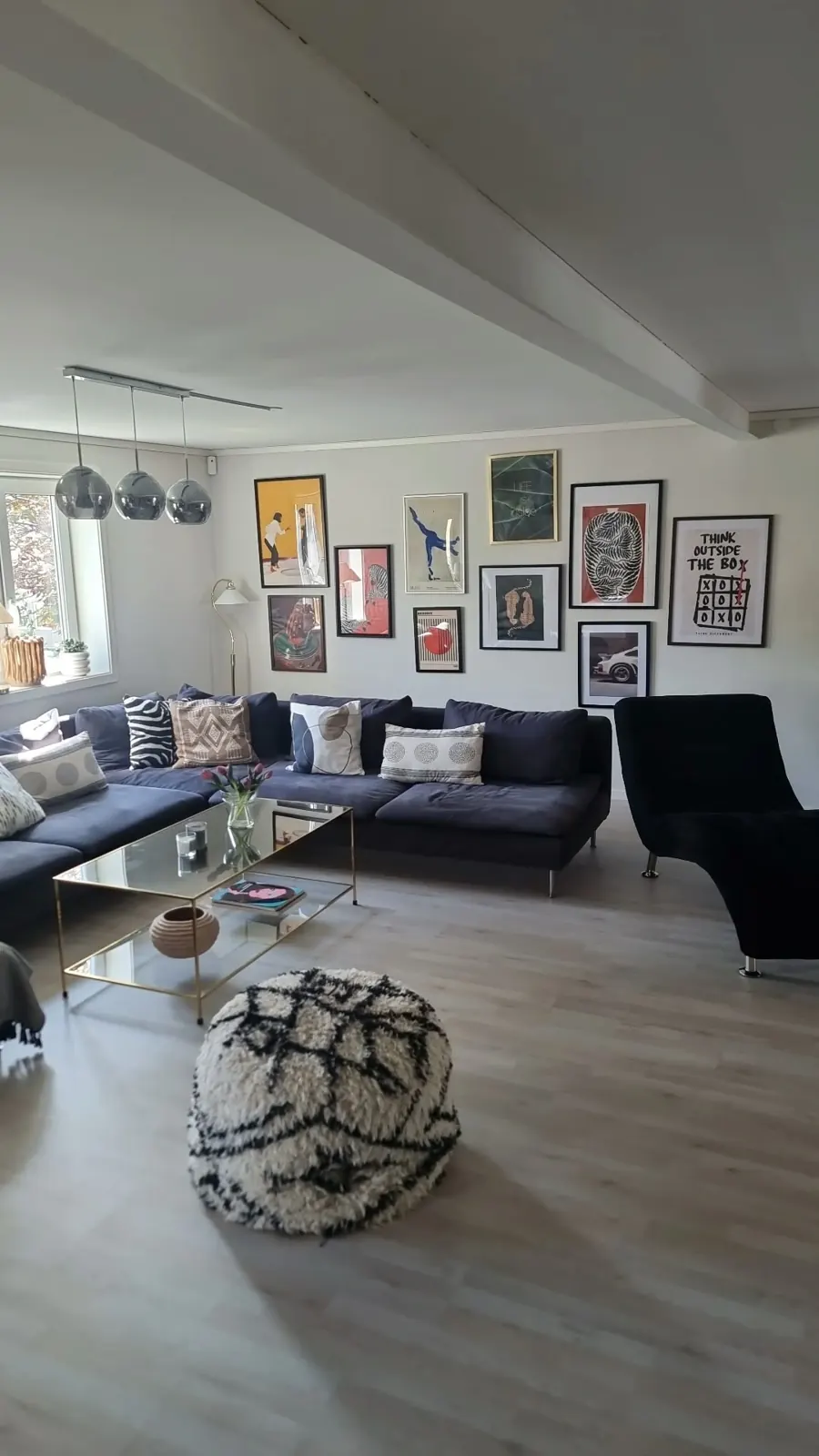 The living room with a blue corner sofa, chaise longue and gallery wall in bright light